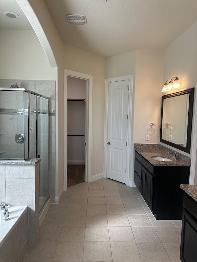 bathroom with a garden tub, visible vents, a spacious closet, a stall shower, and vanity