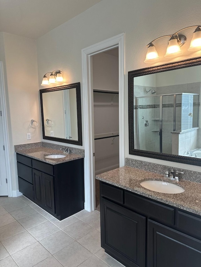 full bathroom featuring tile patterned flooring, a sink, and a shower stall