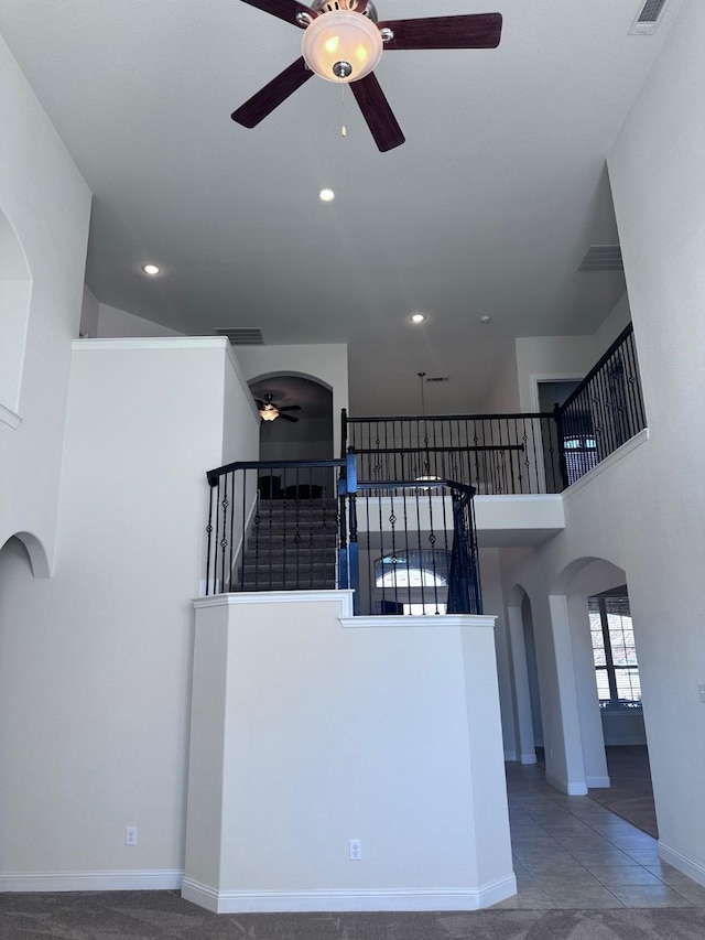 interior space featuring arched walkways, baseboards, visible vents, and recessed lighting