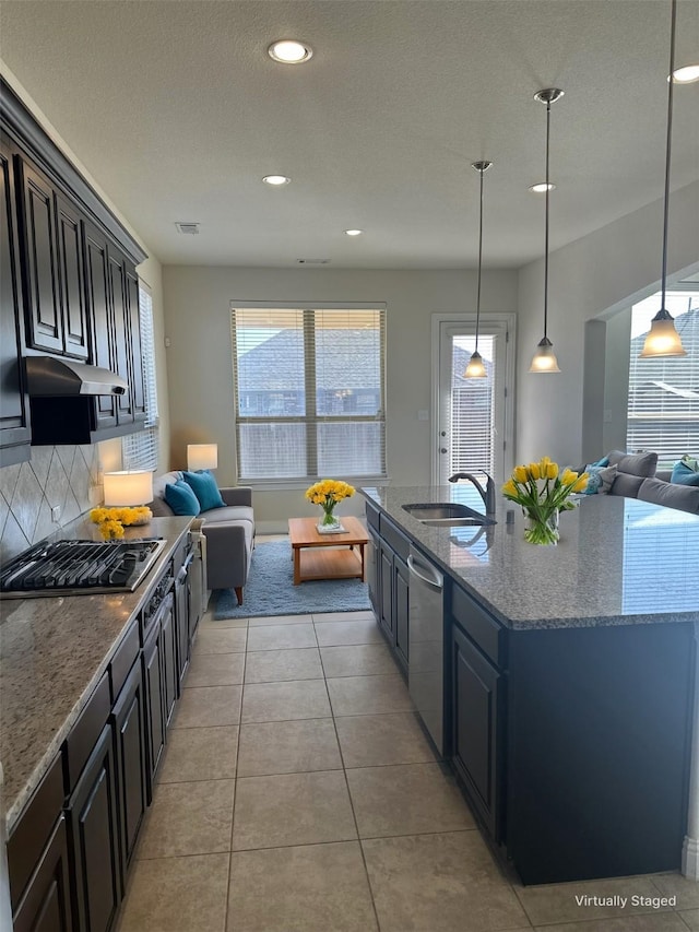 kitchen with open floor plan, stovetop, a sink, and stainless steel dishwasher