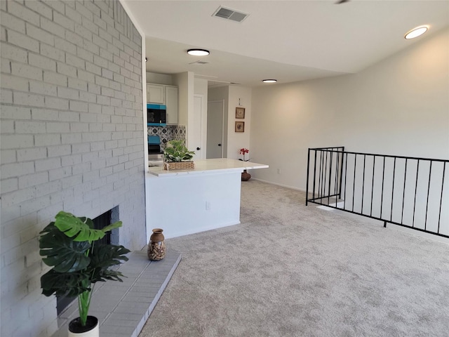 empty room featuring visible vents, a fireplace, and light carpet