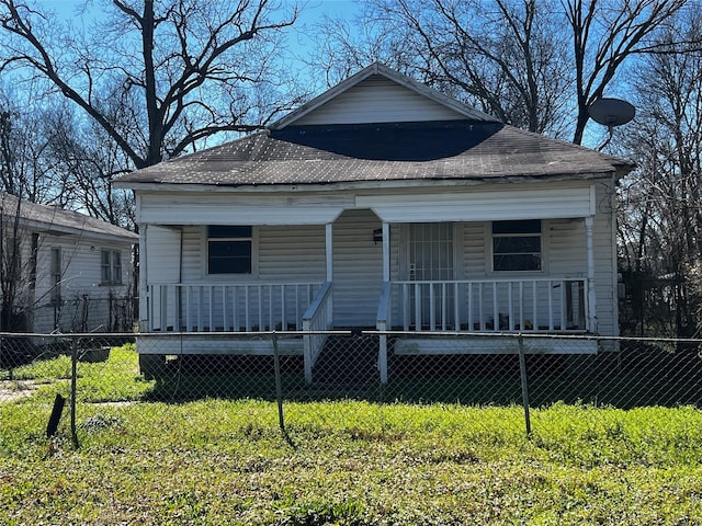 view of front facade with covered porch, a fenced front yard, and a front yard