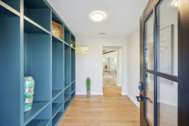 mudroom featuring light wood-style flooring, visible vents, baseboards, and french doors