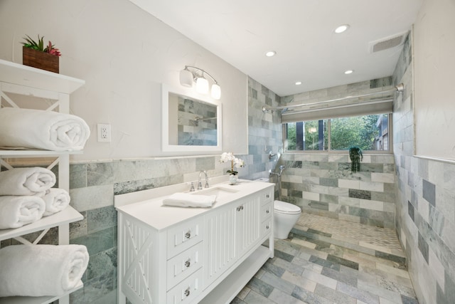 bathroom with tile walls, recessed lighting, visible vents, toilet, and a tile shower