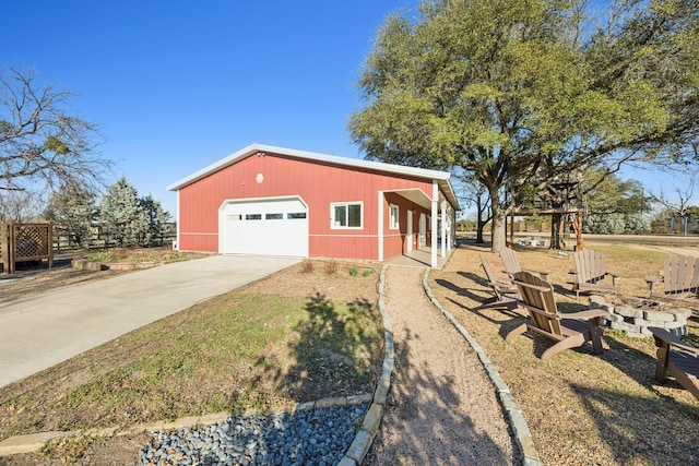 exterior space featuring a garage, concrete driveway, and an outdoor structure