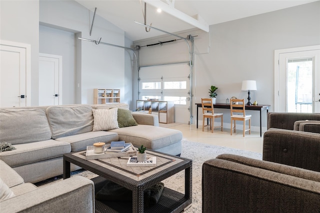 living area with a garage and high vaulted ceiling