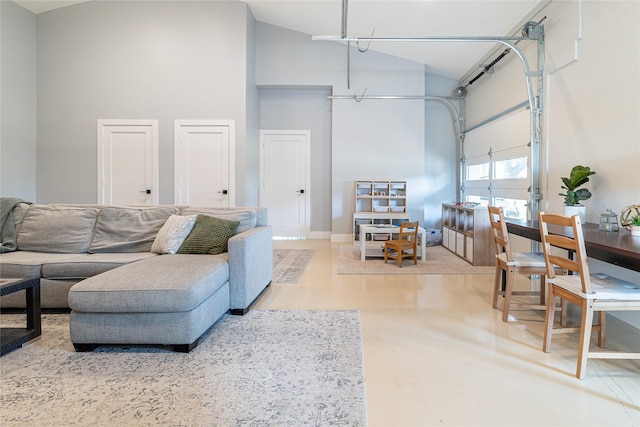 living area featuring a garage and high vaulted ceiling