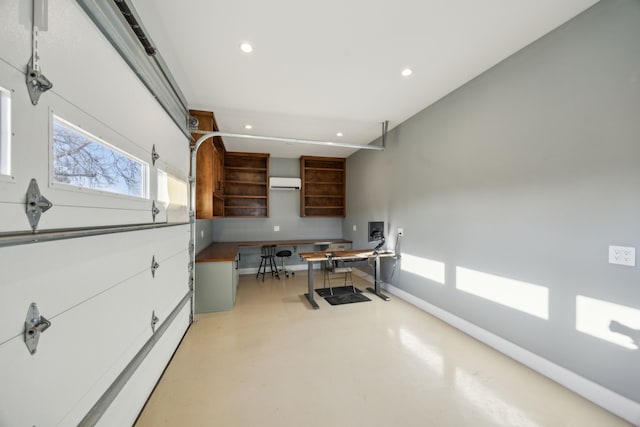 interior space with recessed lighting, a wall mounted air conditioner, finished concrete flooring, and baseboards