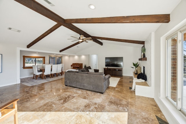 living room featuring a large fireplace, baseboards, visible vents, a ceiling fan, and lofted ceiling with beams