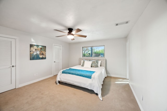 bedroom featuring light carpet, ceiling fan, visible vents, and baseboards