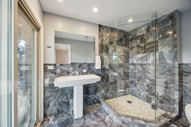 bathroom featuring marble finish floor, a shower stall, toilet, and tile walls