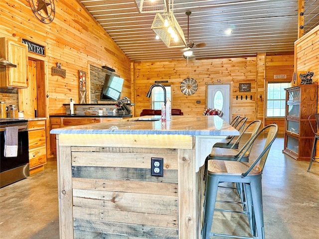 kitchen featuring electric stove, a breakfast bar area, a sink, and finished concrete floors