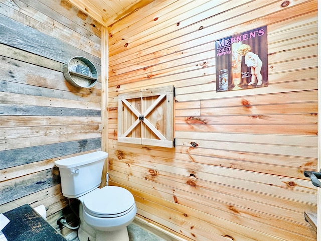 bathroom featuring wood walls and toilet