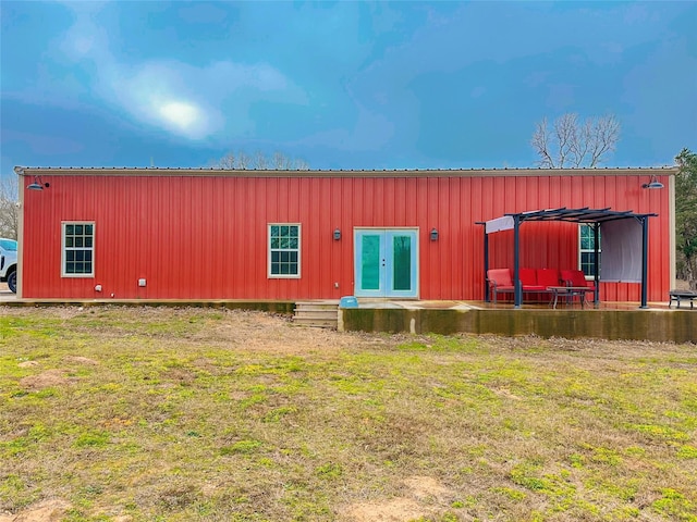 rear view of property with metal roof, a lawn, and french doors