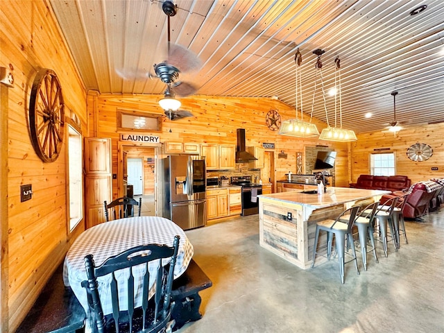 kitchen featuring stainless steel fridge, wooden walls, electric range oven, light countertops, and exhaust hood