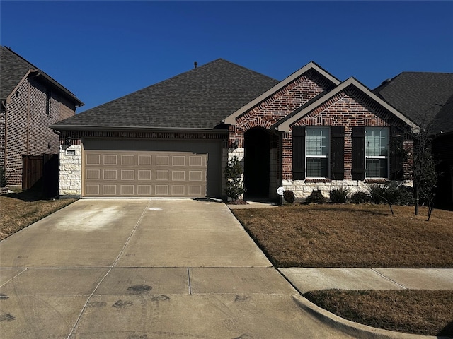 ranch-style house featuring a garage, concrete driveway, stone siding, roof with shingles, and brick siding