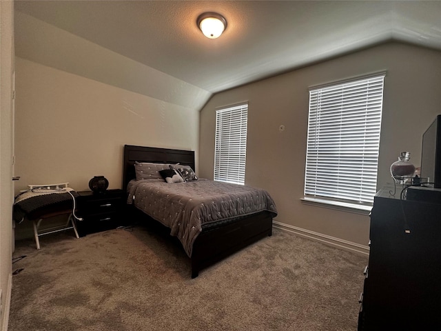 carpeted bedroom featuring lofted ceiling and baseboards