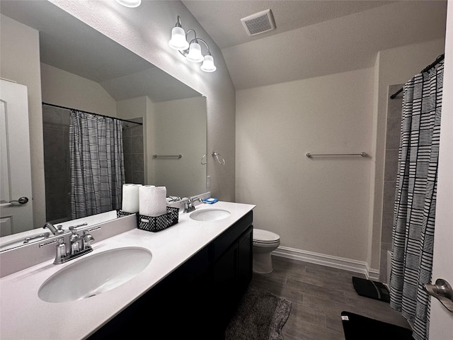 full bath featuring lofted ceiling, visible vents, a sink, and wood finished floors