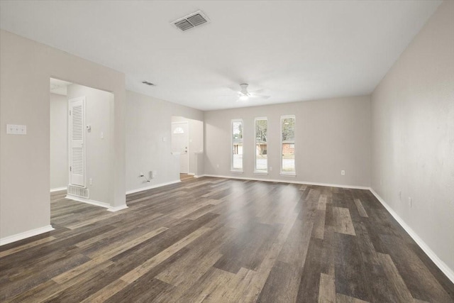 spare room featuring dark wood-style floors, ceiling fan, visible vents, and baseboards