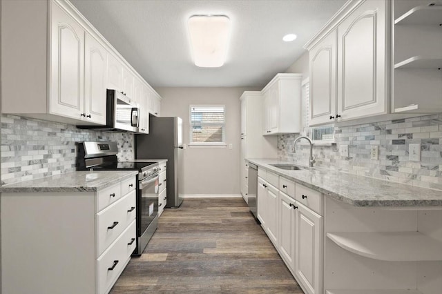 kitchen featuring open shelves, appliances with stainless steel finishes, a sink, and white cabinetry