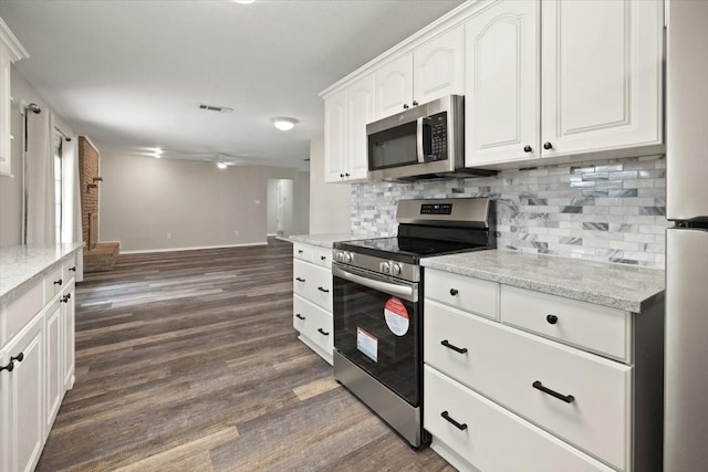 kitchen with dark wood finished floors, stainless steel appliances, visible vents, decorative backsplash, and white cabinets