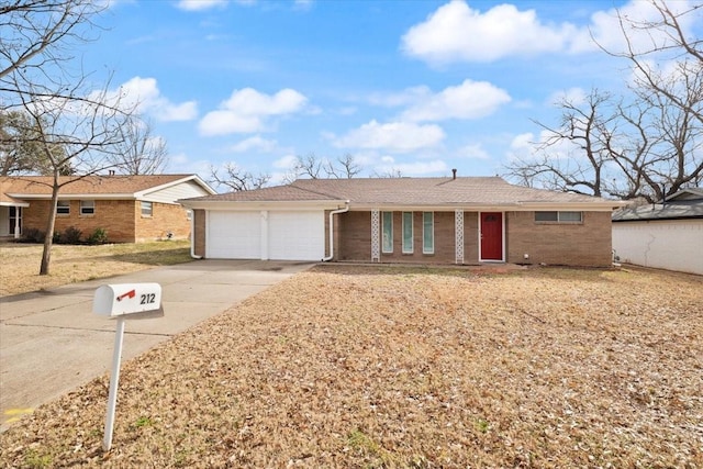 single story home with driveway, an attached garage, and brick siding