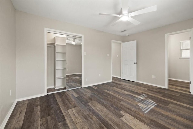 unfurnished bedroom with a closet, dark wood-style flooring, baseboards, and a ceiling fan