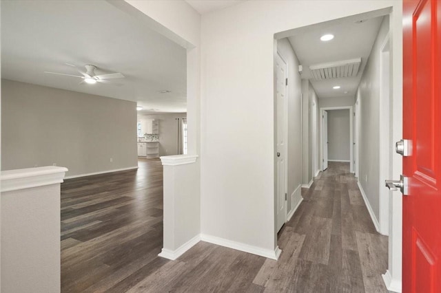 corridor featuring baseboards, visible vents, and dark wood finished floors