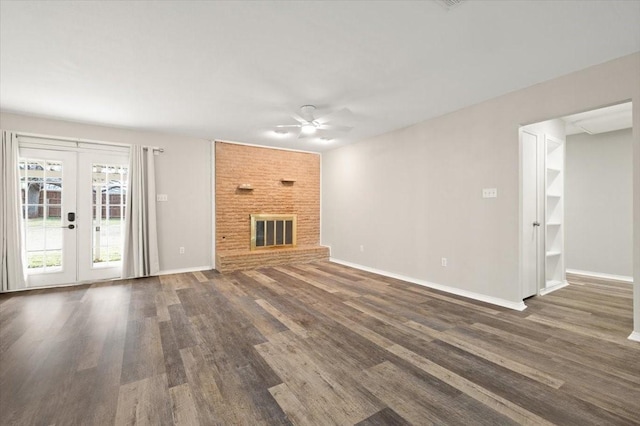 unfurnished living room featuring baseboards, ceiling fan, wood finished floors, french doors, and a fireplace