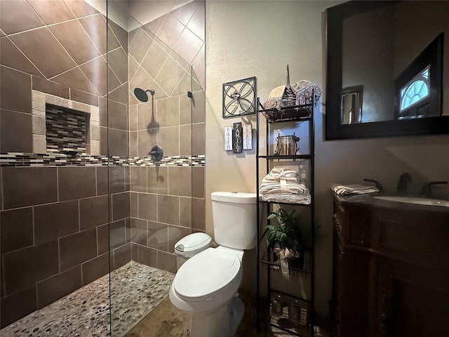 bathroom featuring toilet, walk in shower, and vanity