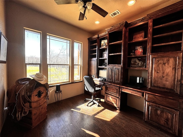 office space featuring dark wood-style flooring, recessed lighting, visible vents, built in study area, and ceiling fan