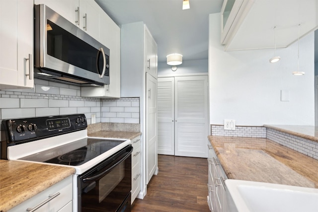 kitchen featuring electric range, stainless steel microwave, white cabinetry, and decorative backsplash