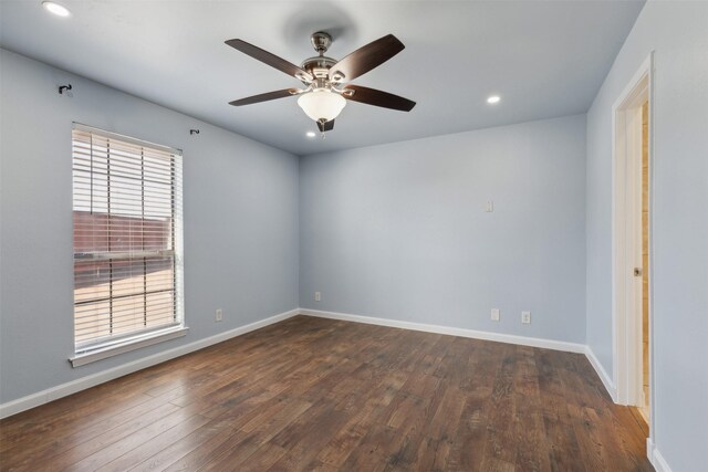 empty room with baseboards, dark wood-style flooring, and ceiling fan