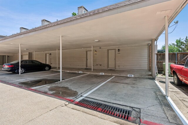covered parking lot featuring fence