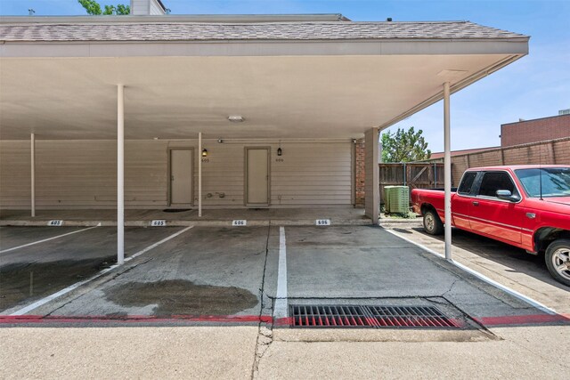 covered parking lot featuring fence