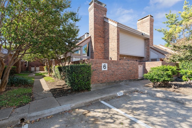 18240 Midway Rd Unit 606, Dallas, TX 75287 - view of side of property featuring a chimney and brick siding