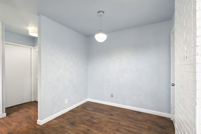 unfurnished room featuring baseboards and wood finished floors
