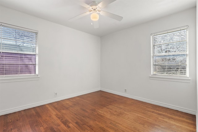 empty room featuring baseboards, a ceiling fan, and wood finished floors