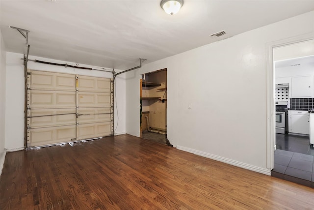 garage featuring baseboards and visible vents