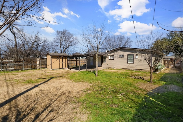 rear view of property featuring an outbuilding, a lawn, a patio area, and a fenced backyard