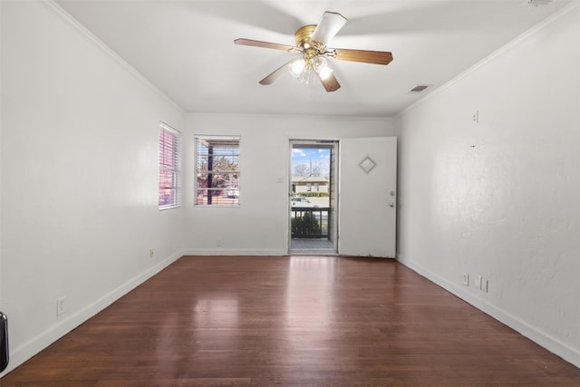 spare room featuring baseboards, visible vents, a ceiling fan, wood finished floors, and crown molding