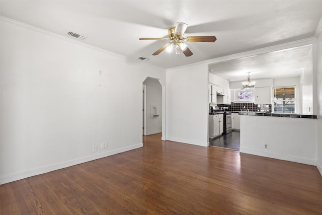 unfurnished living room with visible vents, crown molding, arched walkways, and dark wood-style flooring