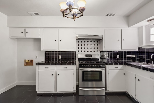 kitchen featuring stainless steel gas range oven, a sink, visible vents, tile counters, and range hood