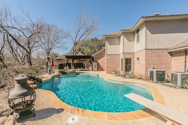 view of pool with a patio area, central AC, and a diving board