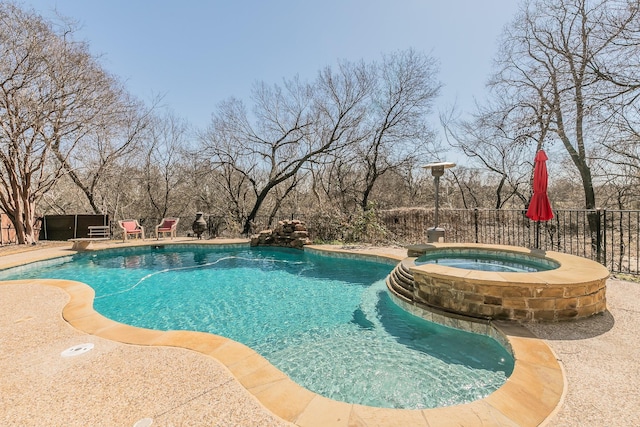 view of swimming pool with a pool with connected hot tub and fence