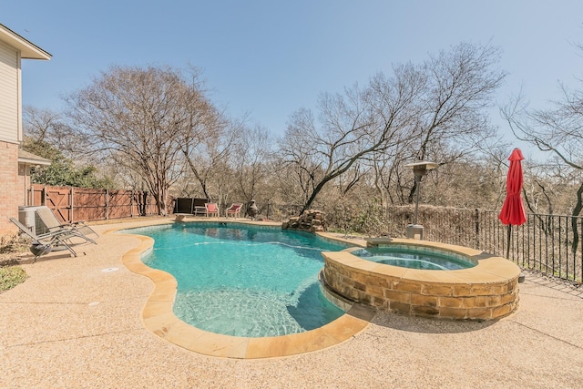 view of pool featuring a patio area, a fenced backyard, and a pool with connected hot tub