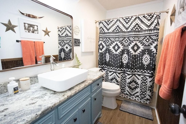 full bath featuring a shower with shower curtain, toilet, ornamental molding, wood finished floors, and vanity