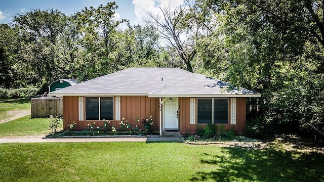 view of front facade featuring a front lawn and fence