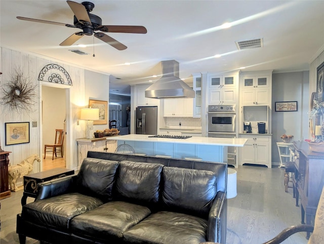 living room featuring visible vents, wood finished floors, and ornamental molding