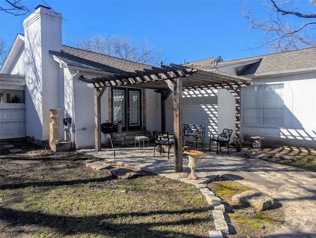 back of property with brick siding, a patio, a chimney, and a pergola